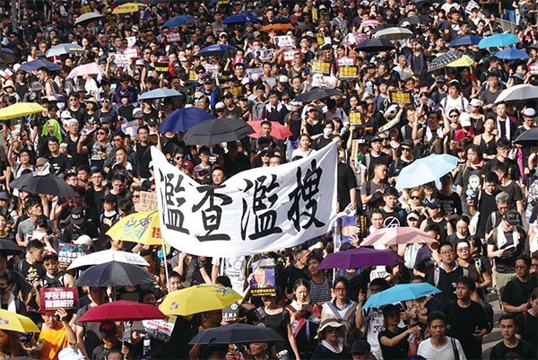 2019年7月21日，香港，民陣發起的反送中遊行隊伍中，有市民舉起橫幅抗議警方「濫查濫搜」。（余鋼／大紀元）