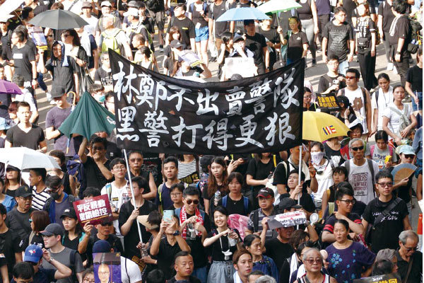 2019年7月21日，香港，民陣發起的反送中遊行隊伍中，有市民舉起「林鄭不出賣警隊 黑警打得更狠」的幅。（余鋼／大紀元）