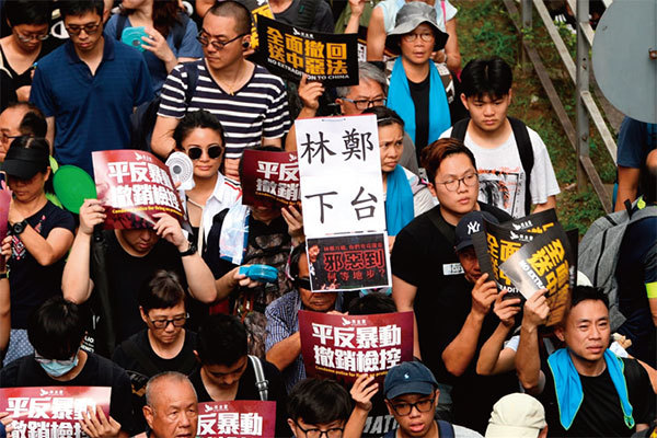 圖1：2019年7月21日，香港，民陣發起的反送中遊行隊伍中，有市民舉著要求林鄭下臺的標語。（宋碧龍／大紀元）